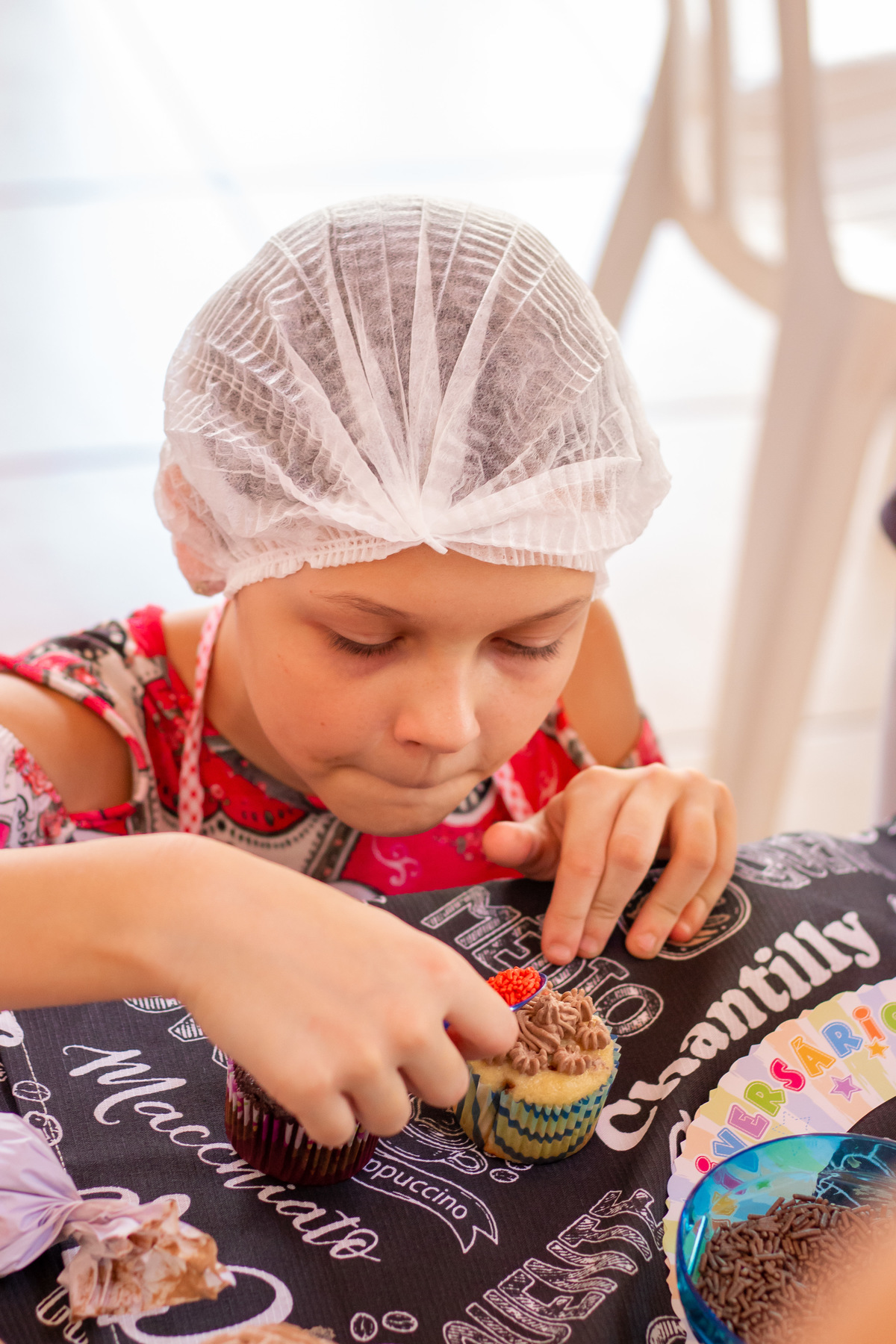 Menina recheando seu cupcake em aniversário