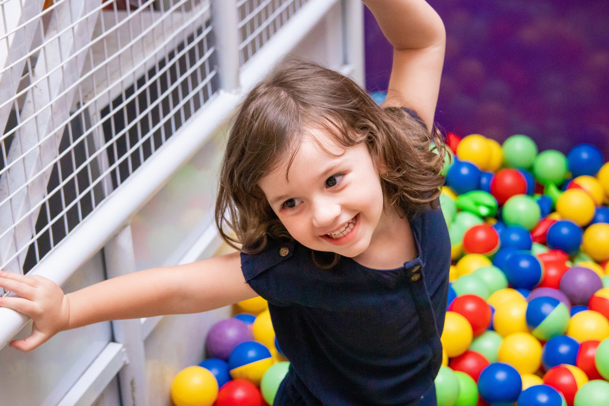 nenê brincando na piscina de bolinha
