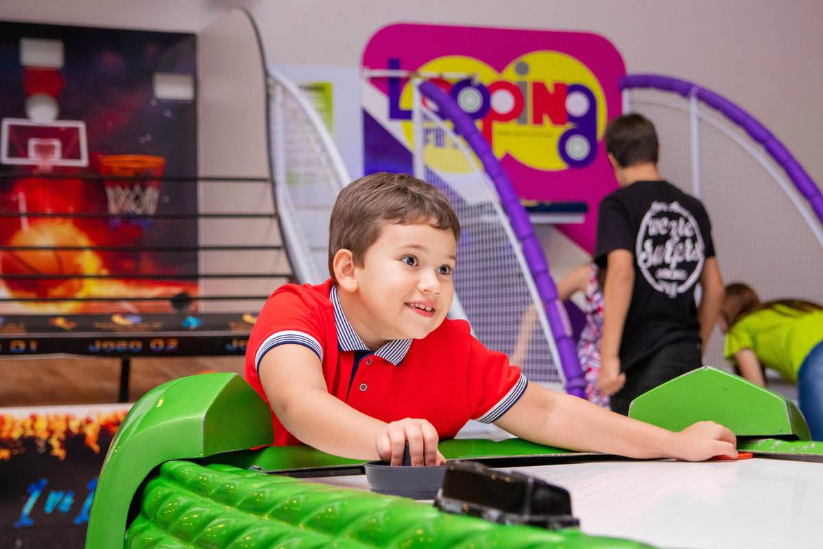menino jogando air hockey