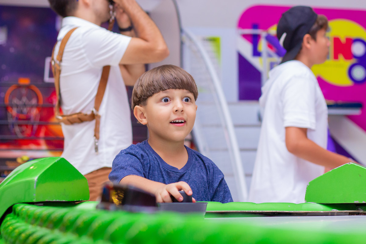 menino surpreso no air hockey