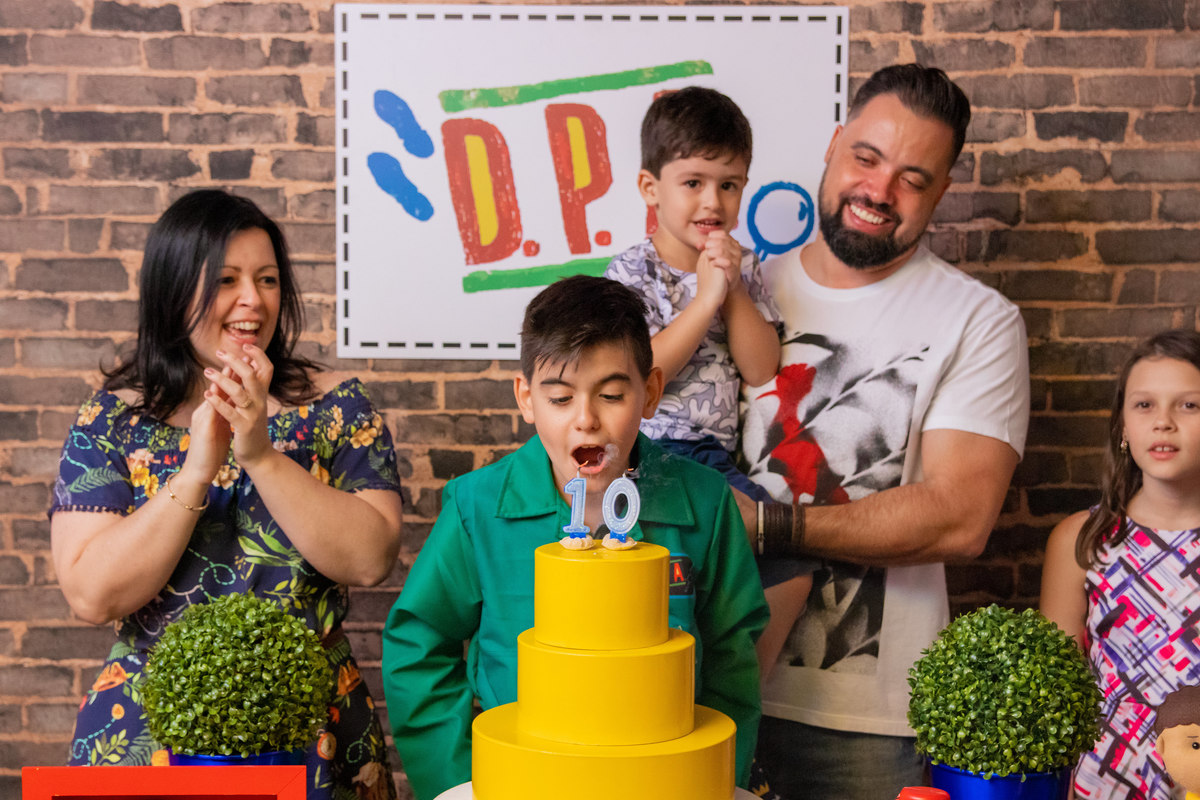 Aniversariante e sua família assoprando as velinhas