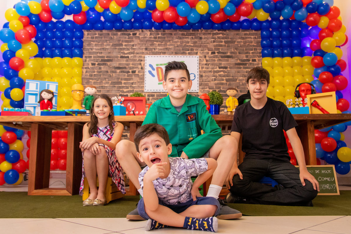 Aniversariante e seus primos na mesa do bolo