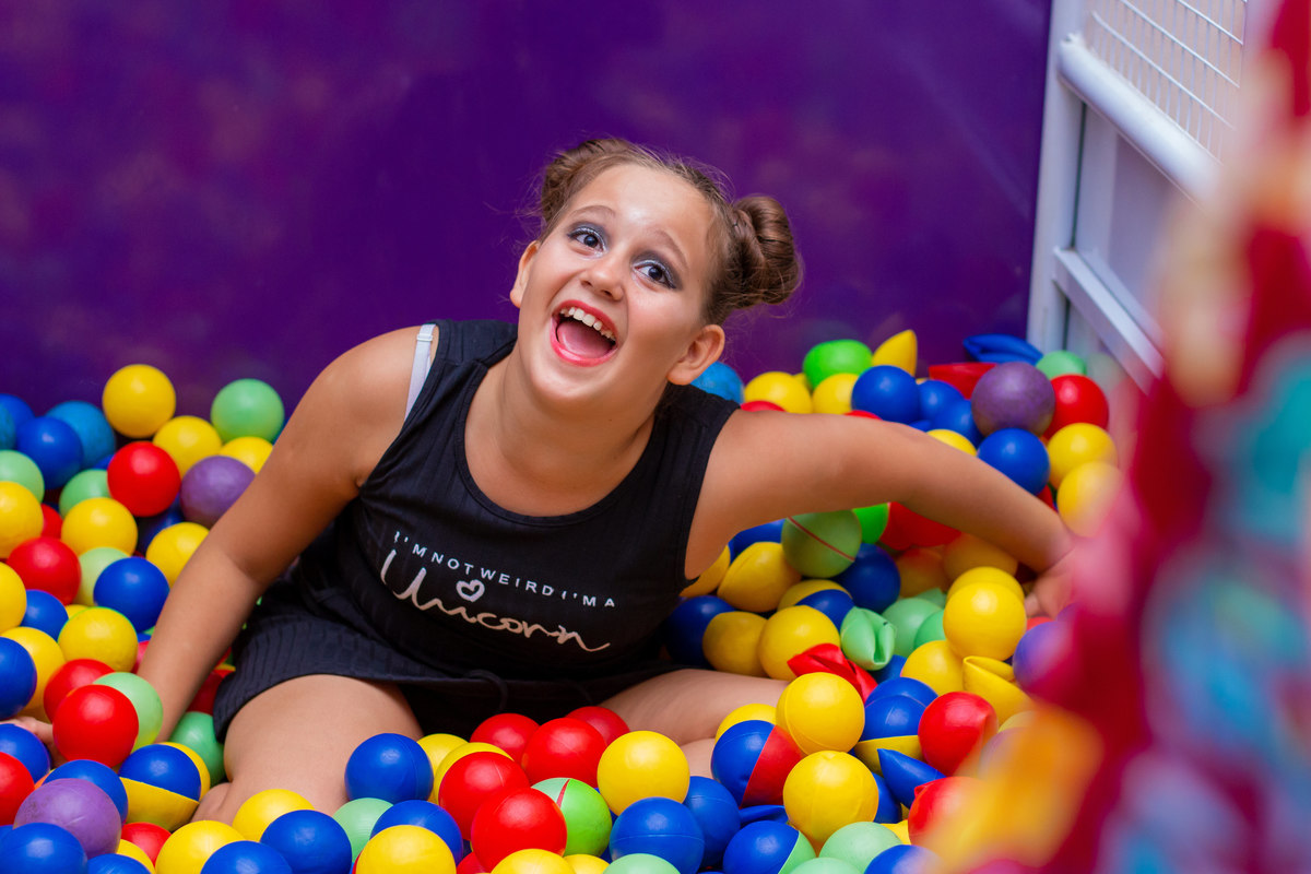 menina animada na piscina de bolinhas