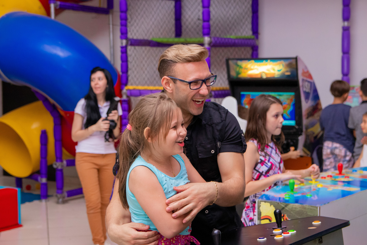 Pai e filha brincando no video game em aniversário