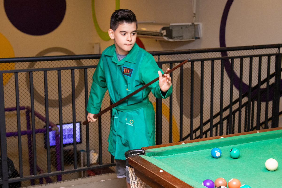 Aniversariante jogando sinuca em seu aniversário