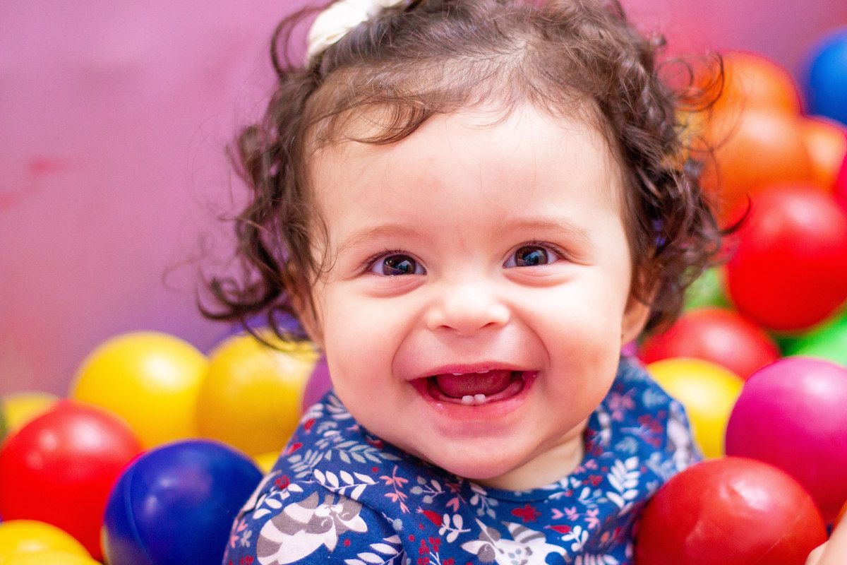 nenê sorridente na piscina de bolinhas