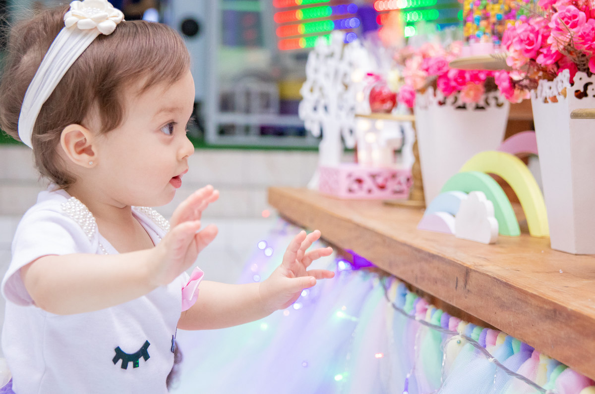 Aniversariante brincando na mesa do bolo