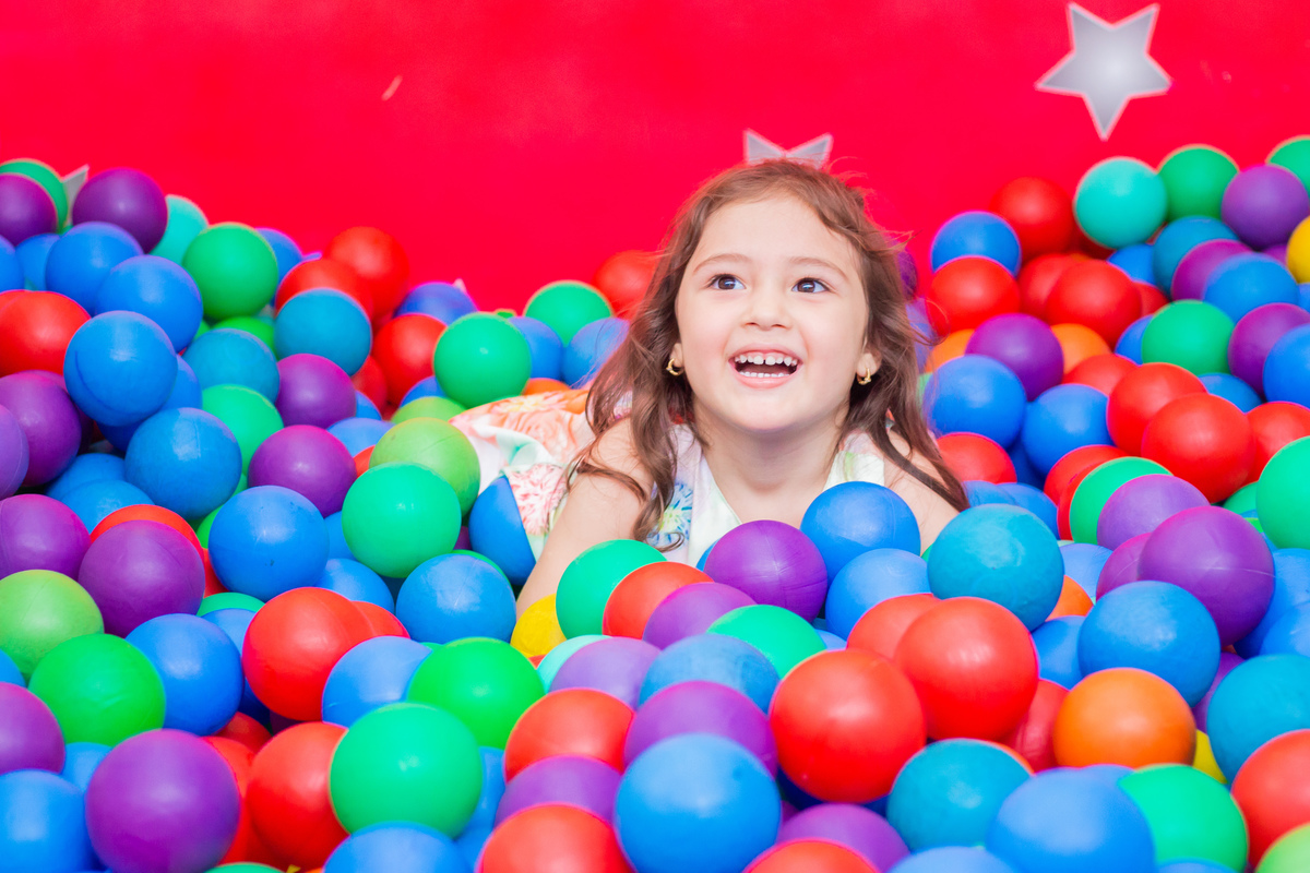 Menininha brincando na piscina de bolinhas