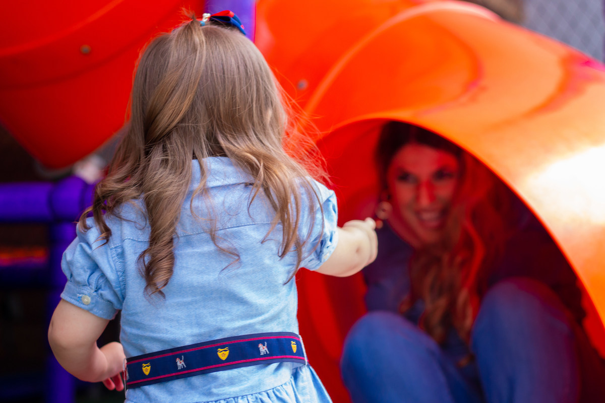 Aniversariante brincando com sua mãe em escorregador