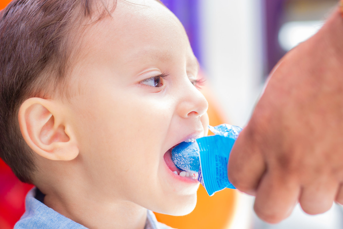 Menino comendo picolé em aniversário