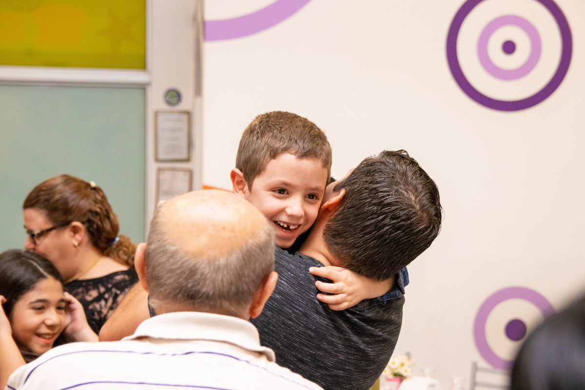 Menino feliz ao receber abraço