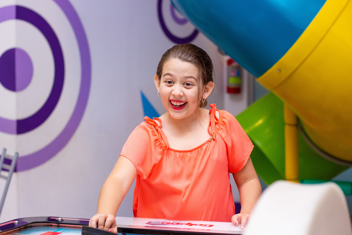 menina se divertindo no air hockey