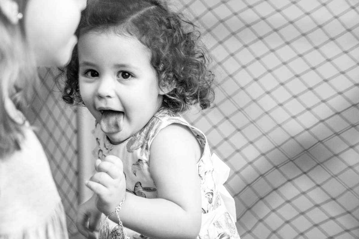 menina mostrando a língua em aniversário infantil