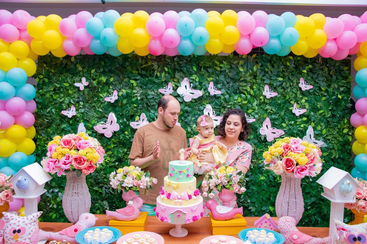 Aniversariante e seus pais na hora do parabéns