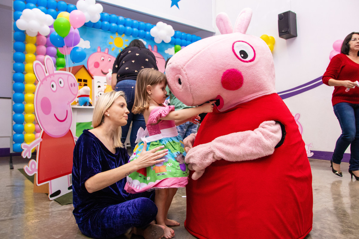 Aniversariante abraçando personagem vivo da peppa pig em aniversário