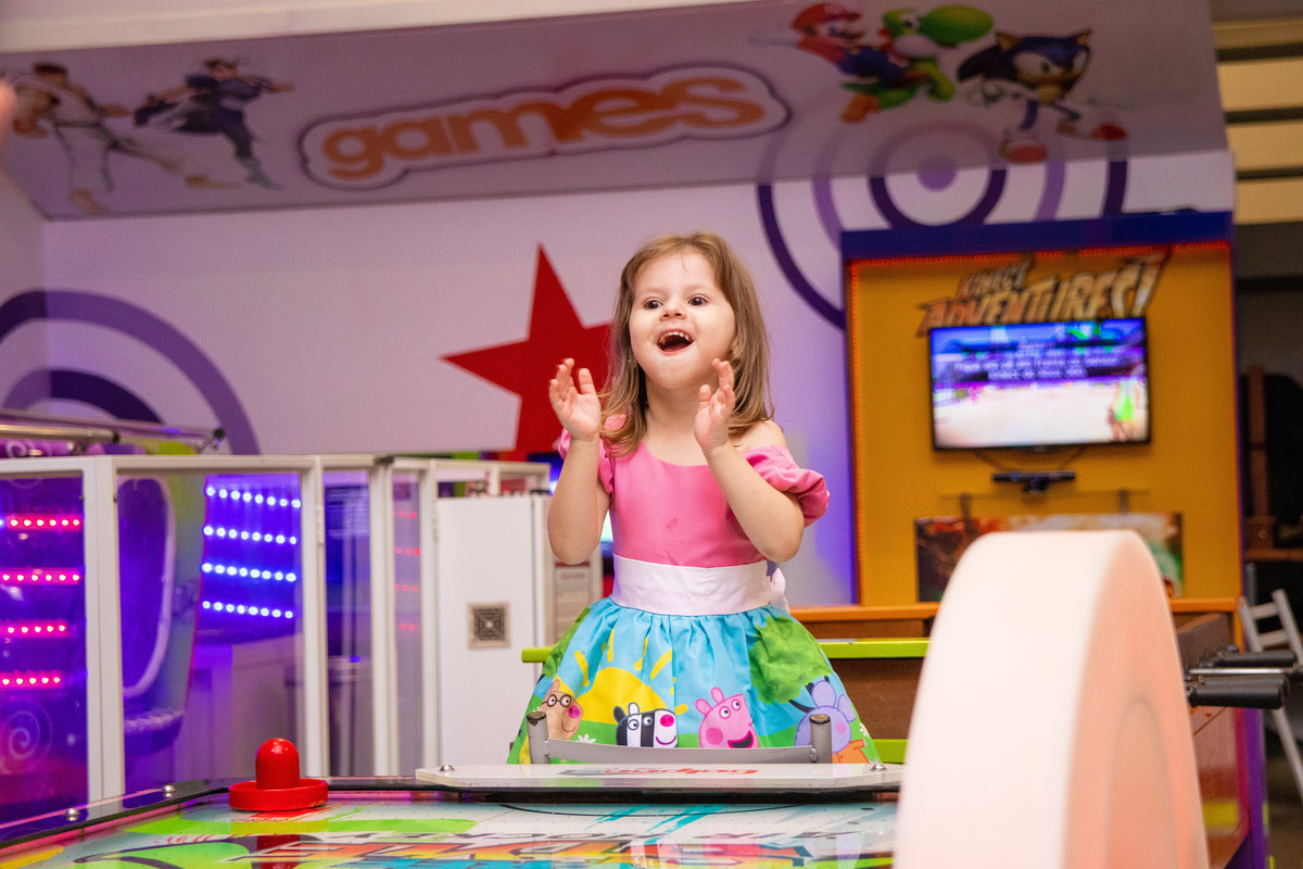 Aniversariante comemorando ao brincar no air hockey