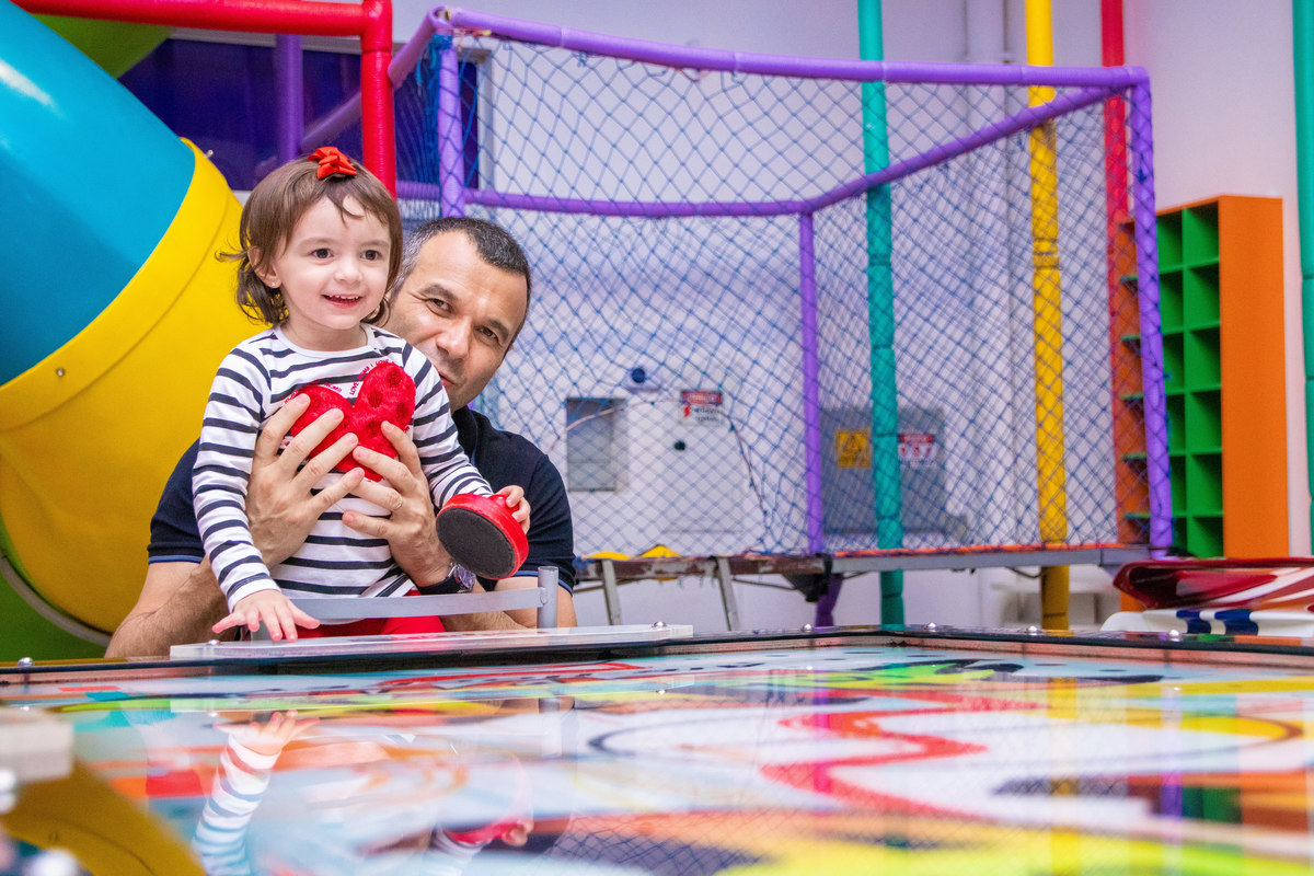 pai e filha brincando no air hockey