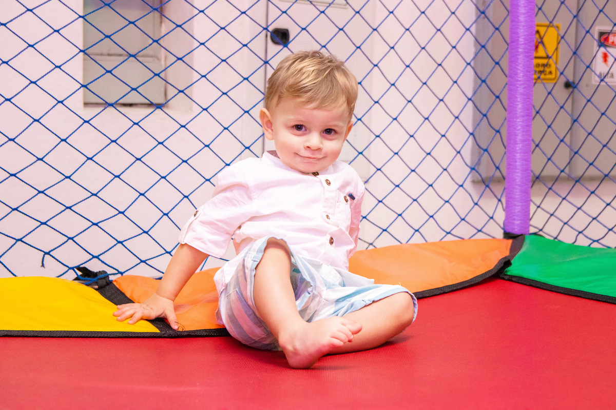 nenê brincando na cama elástica