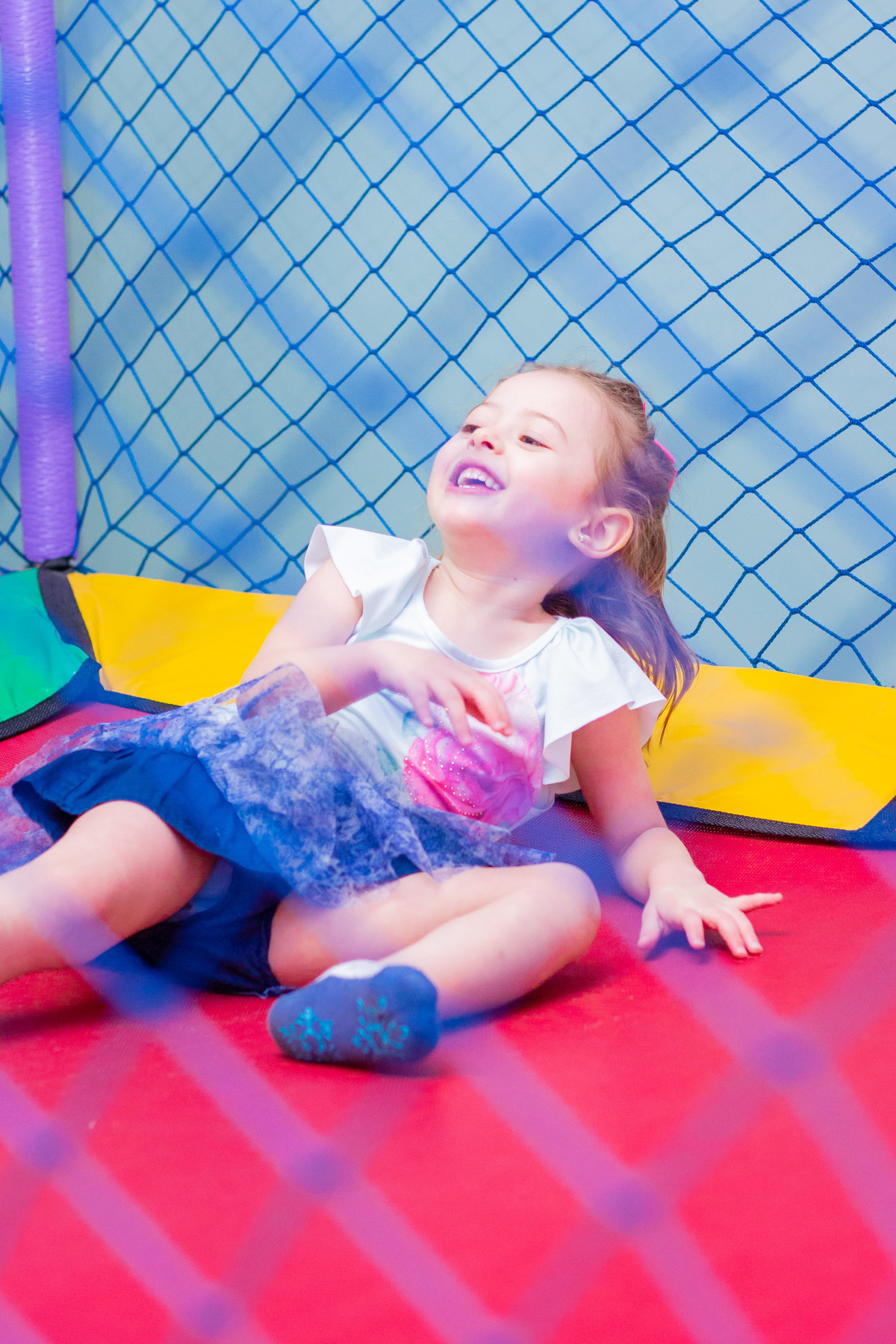 menina rindo na cama elástica