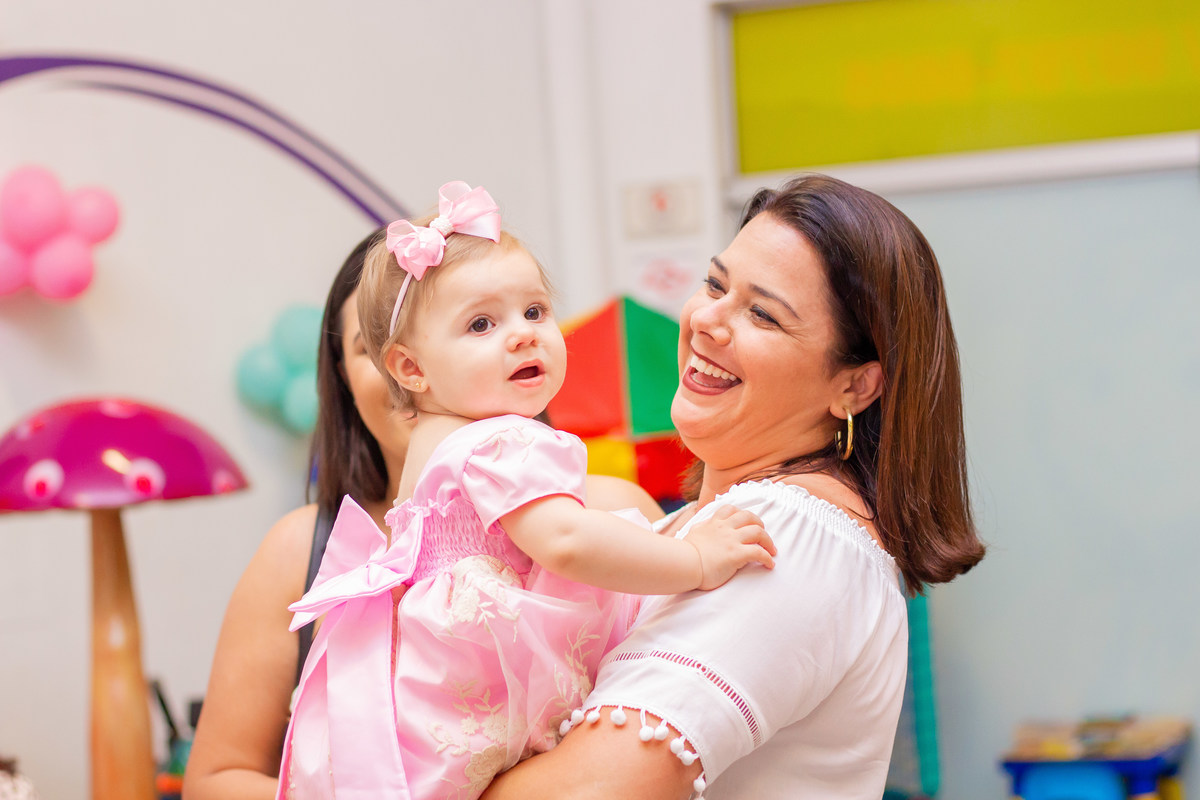 Aniversariante rindo no colo da convidada