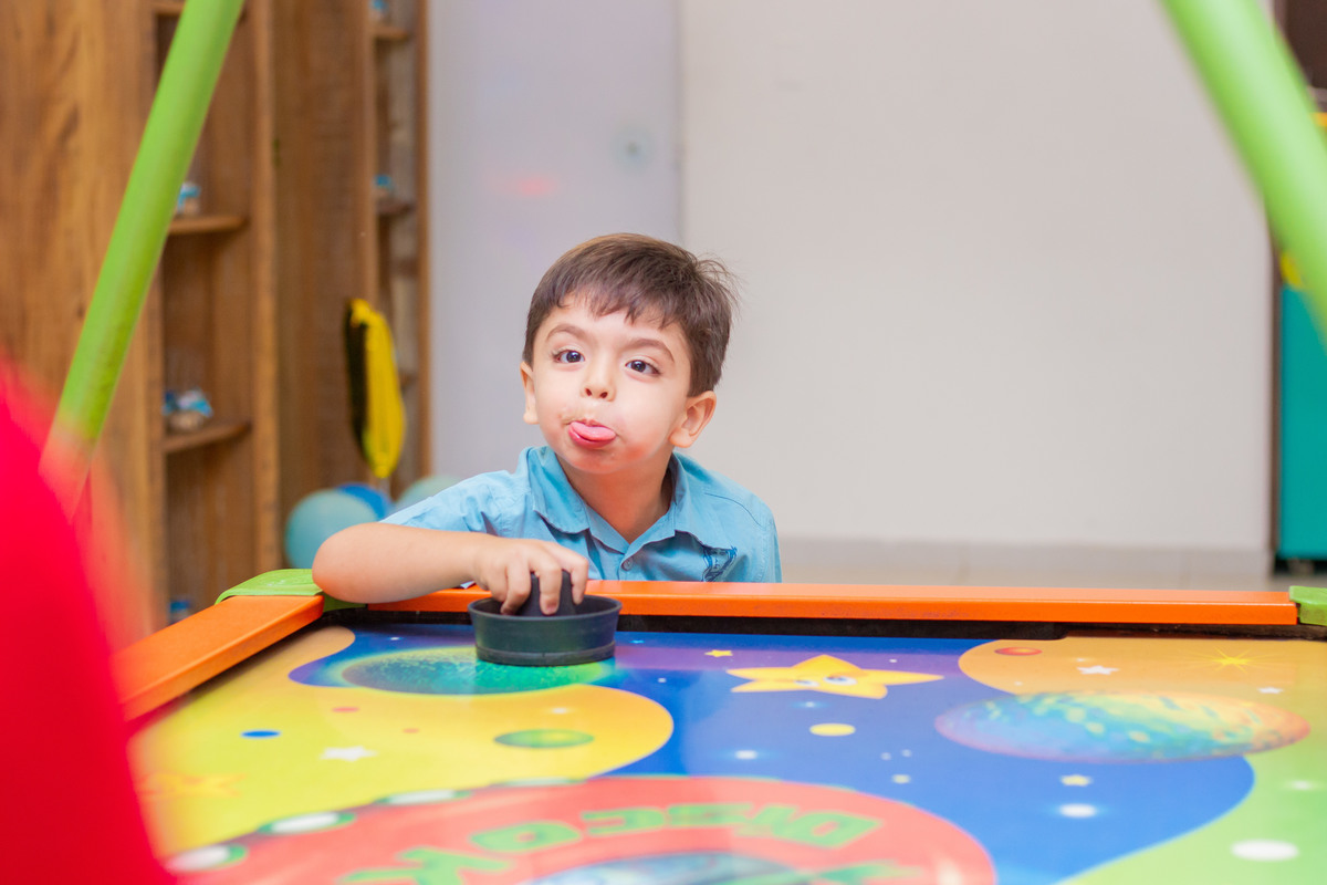 menino brincando no air hockey 