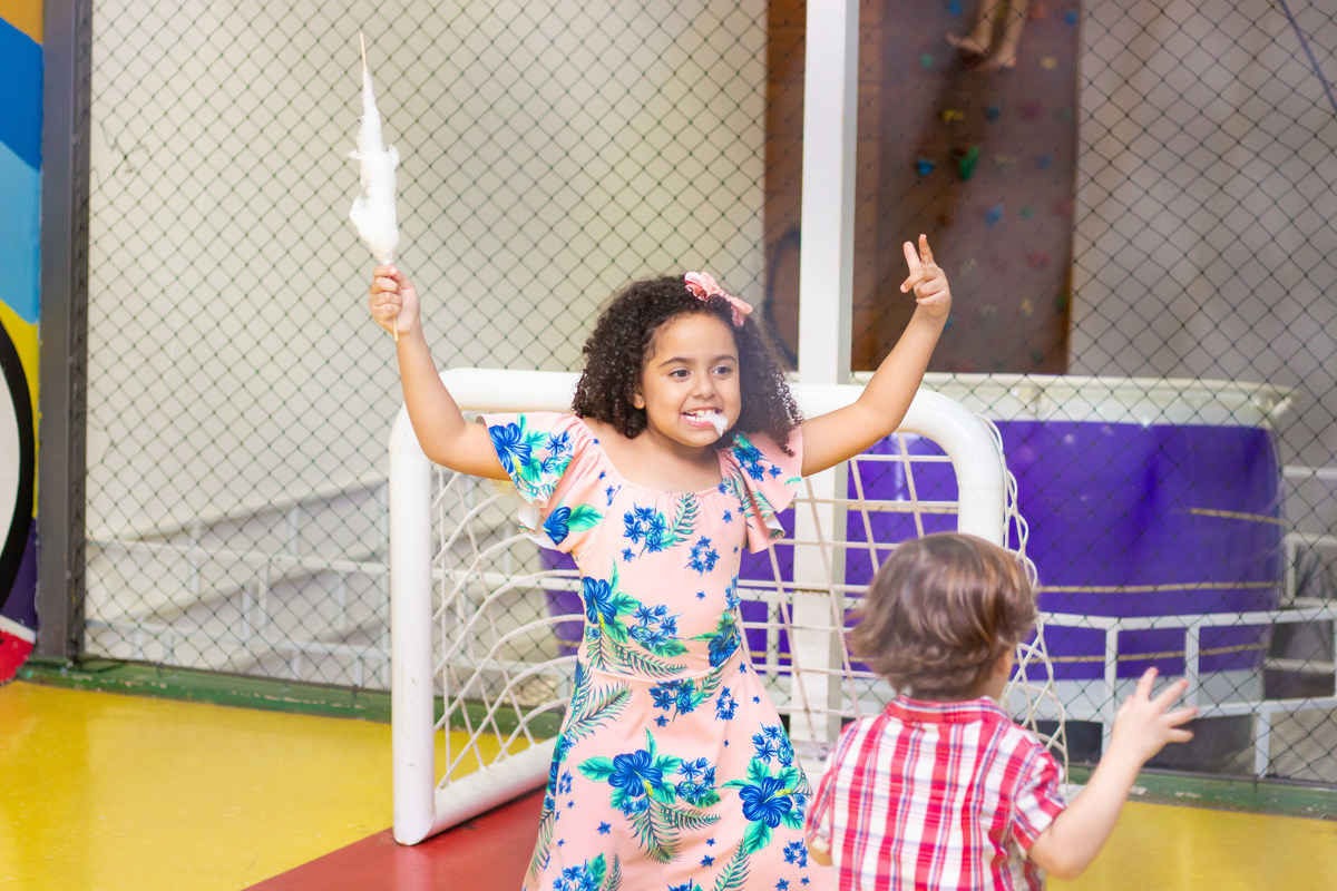menina brincando e comendo algodão doce em aniversário