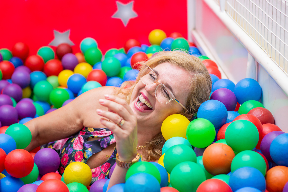 Avó brincando na piscina de bolinhas