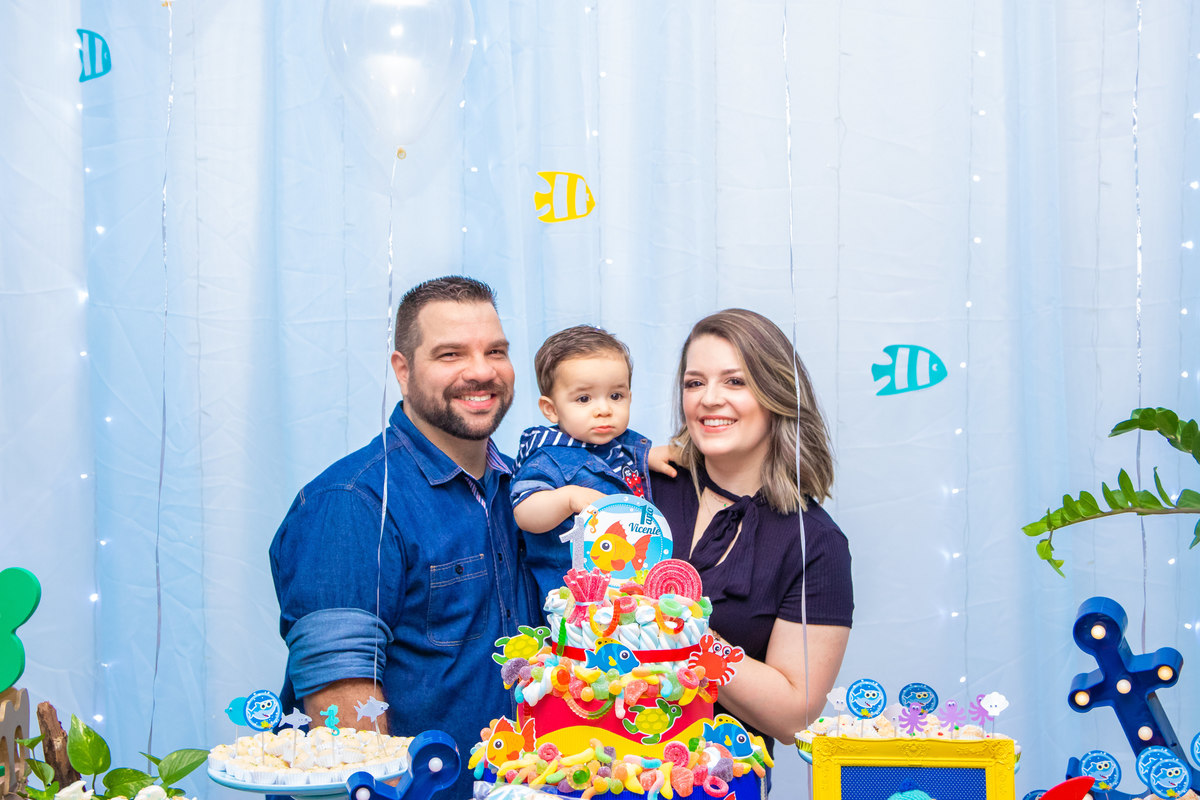 Foto com os pais na mesa do bolo