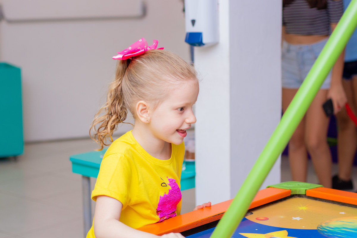 Buffet Zappteen Bauru, menina brincando em air hockey
