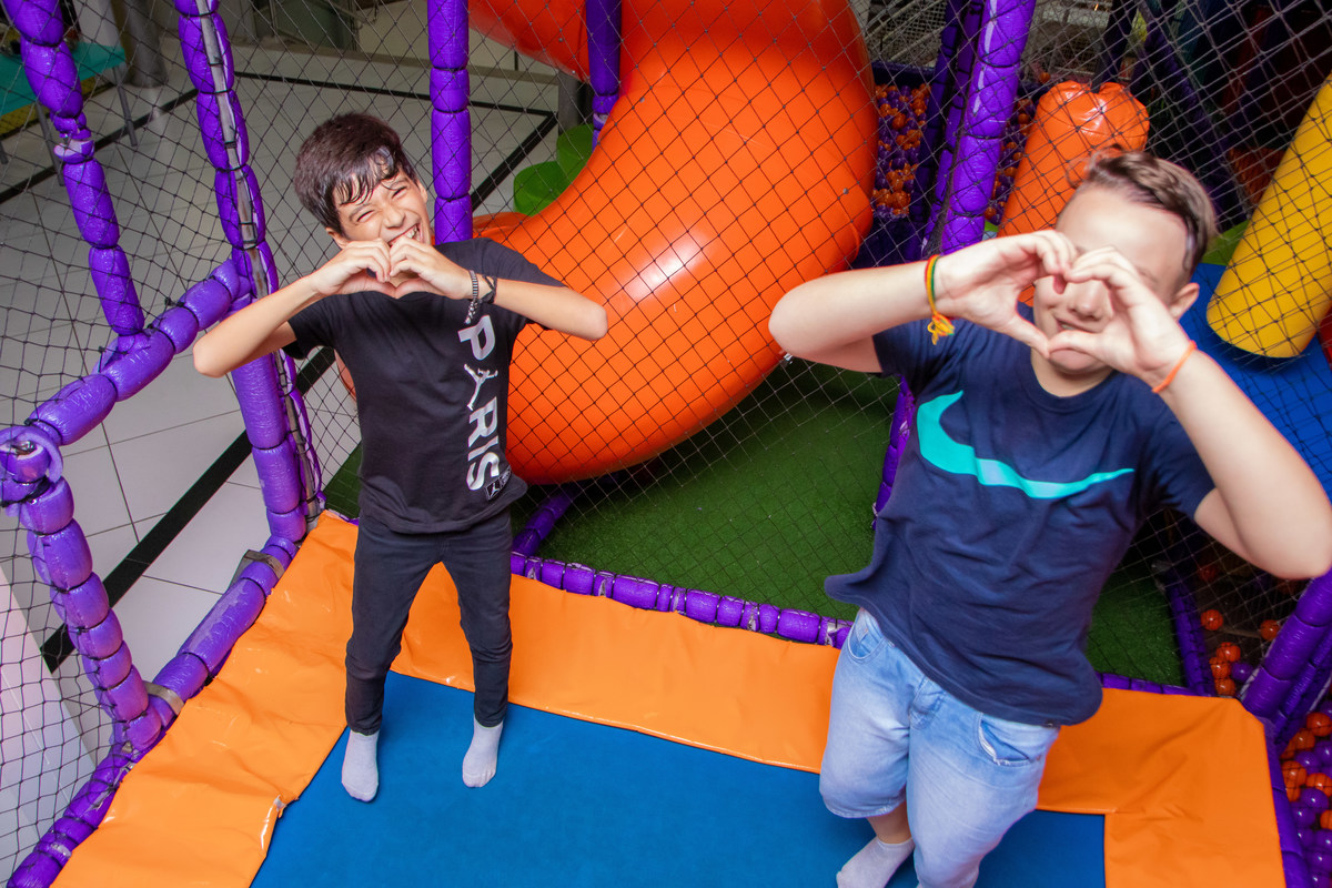 Buffet Zappteen Bauru, amigos fazendo coração com as mãos em cama elástica