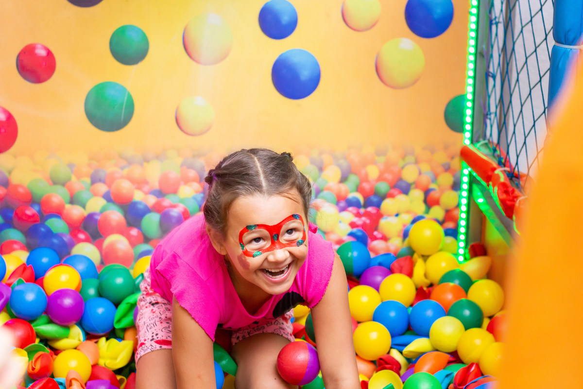 criança se divertindo em piscina de bolinhas