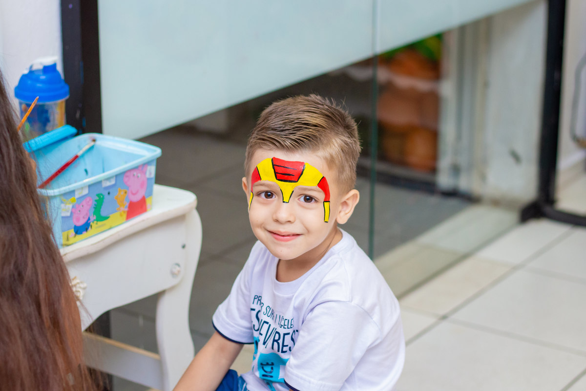 criança fazendo pintura artística do homem de ferro