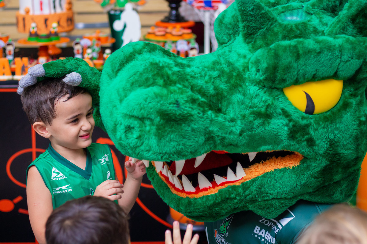 aniversariante brincando com mascote do bauru basket em seu aniversário