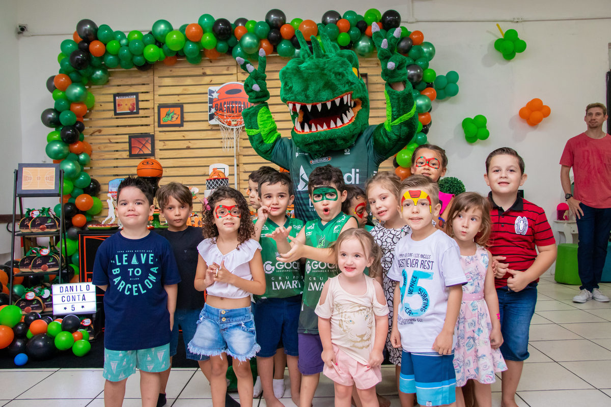 Crianças reunidas para tirar foto com mascote do bauru basket