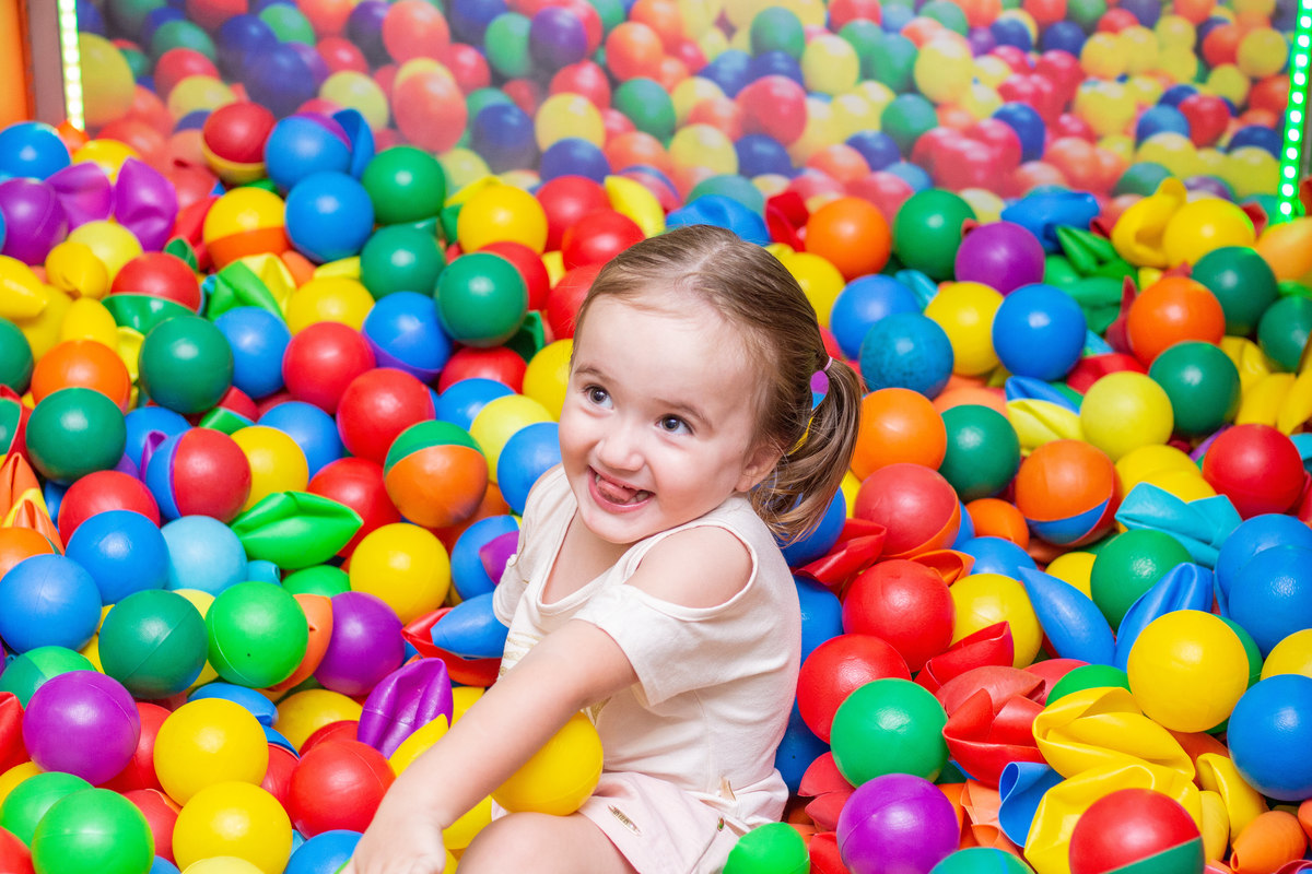 Menininha brincando na piscina de bolinhas