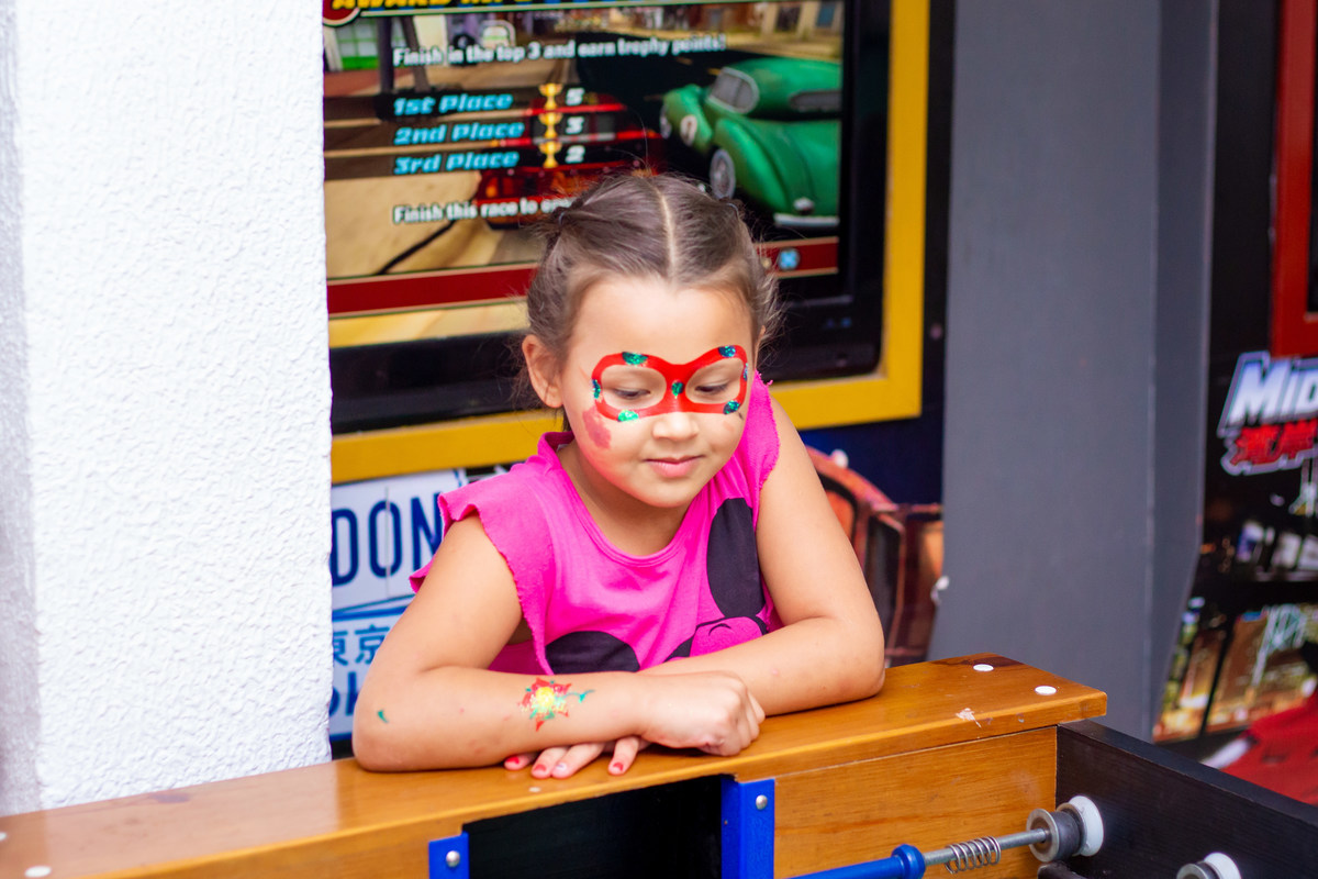 menina com o rosto pintado olhando o pebolim