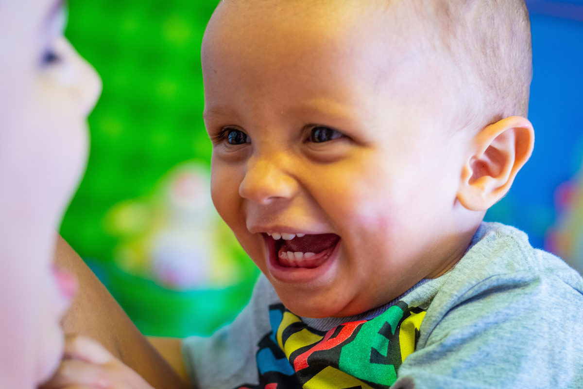 Foto do aniversariante rindo para a mamãe, sorriso espontâneo em aniversário