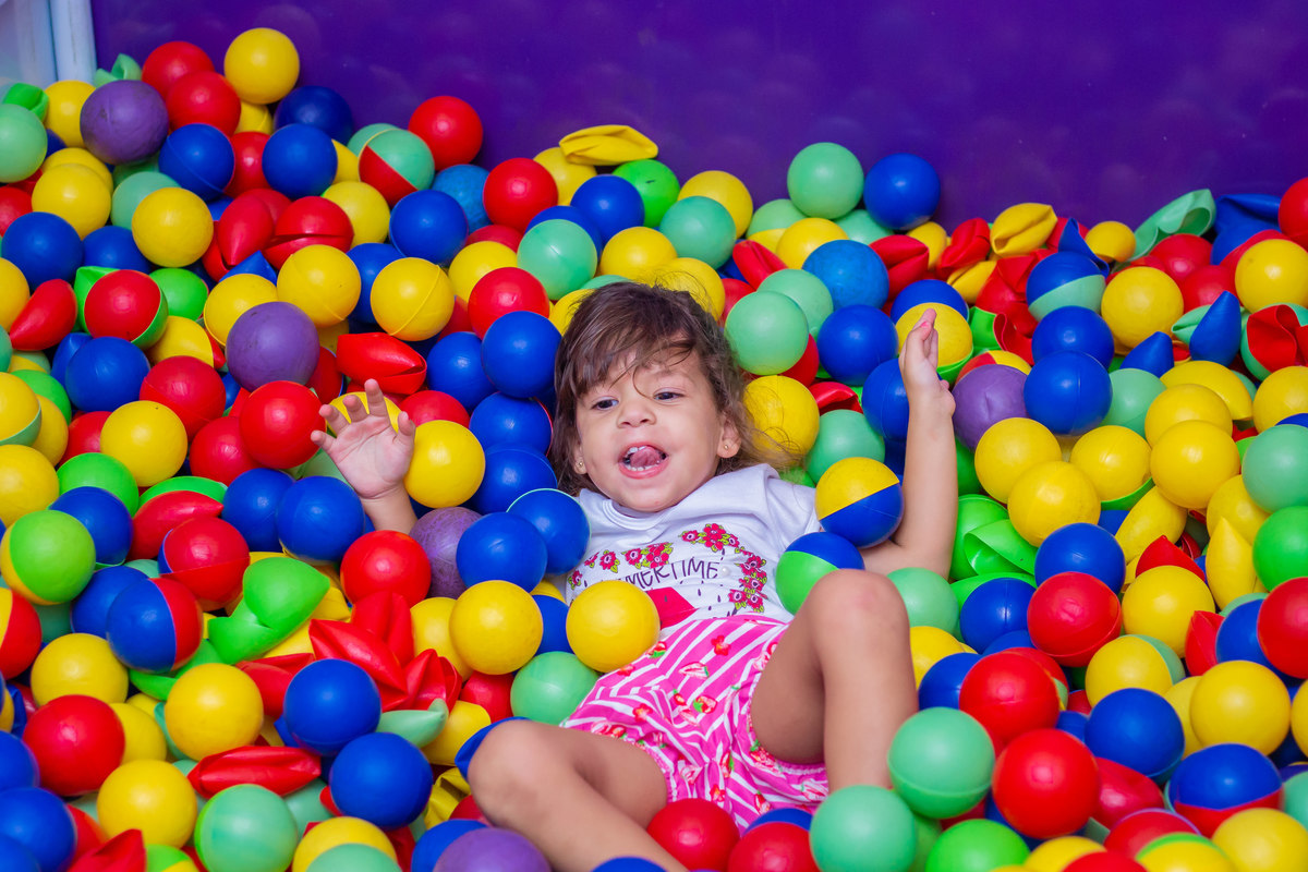 Criança se divertindo em piscina de bolinha