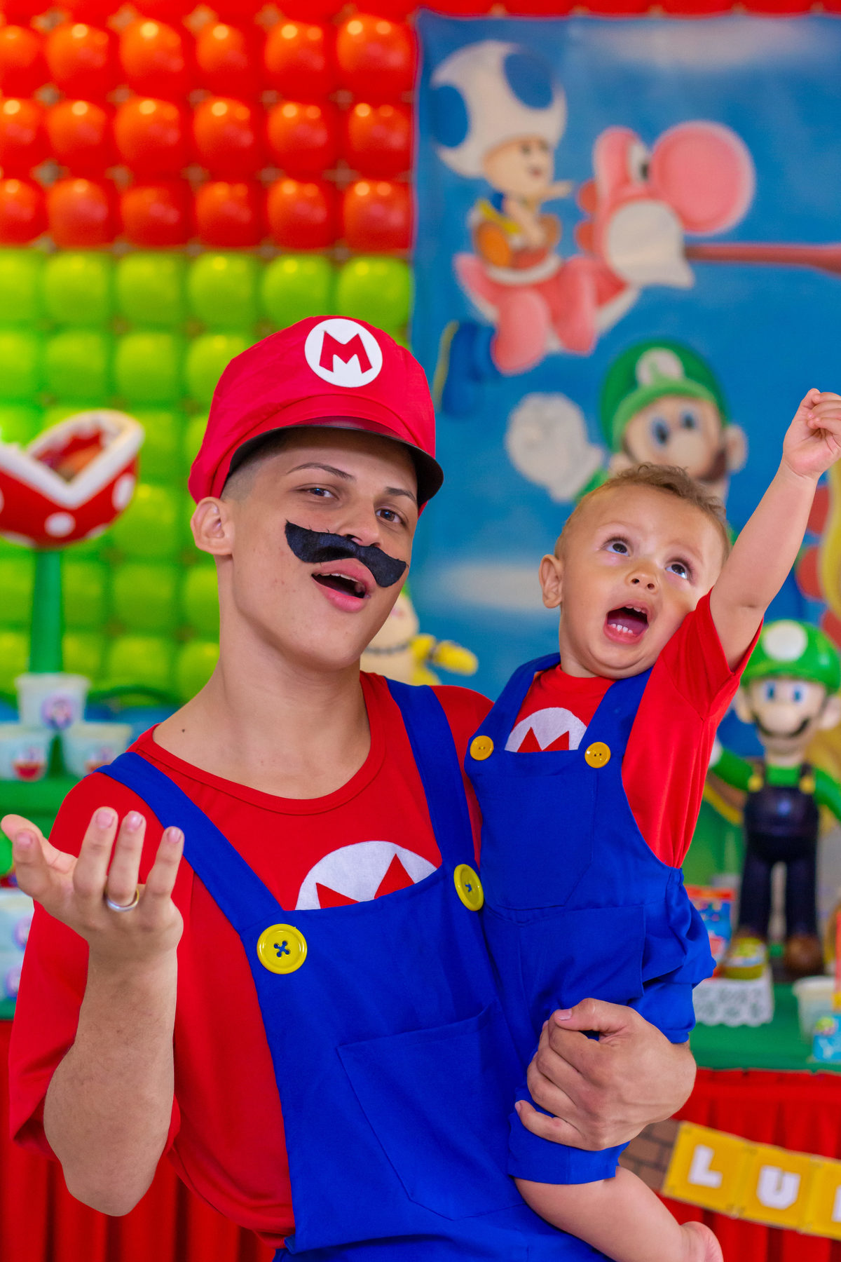 Pai e filho fantasiados de Mario Bros em aniversário