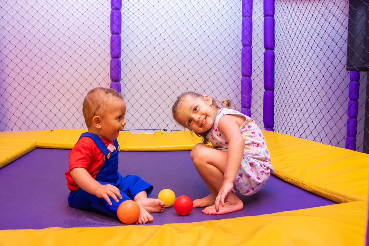 Crianças brincando na cama elástica em aniversário 