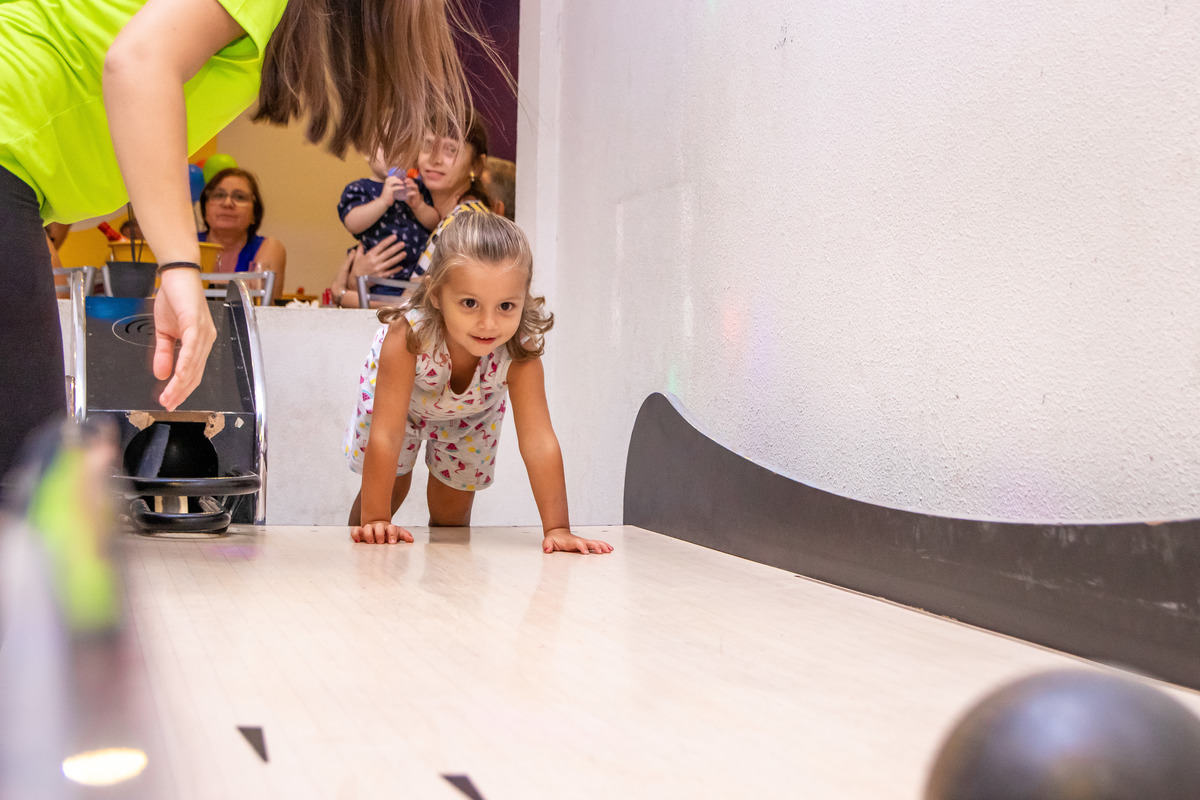 Menina jogando a bola de boliche, bufet Looping Bauru