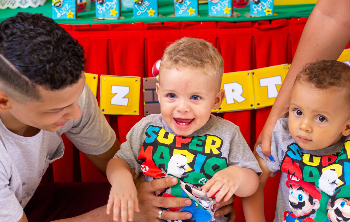 Nenê de 1 ano sorrindo, camiseta de nenê do Mario Bros 