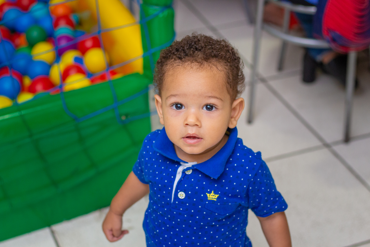 nenê de polo azul olhando para a câmera