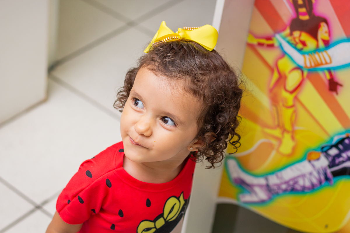 nenê com laço amarelo fazendo careta