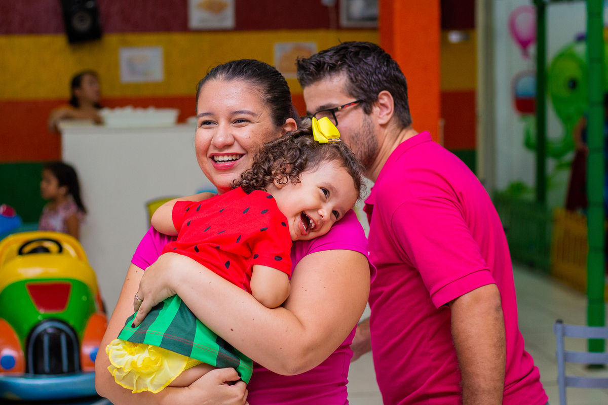 Aniversariante sorrindo no colo da convidada