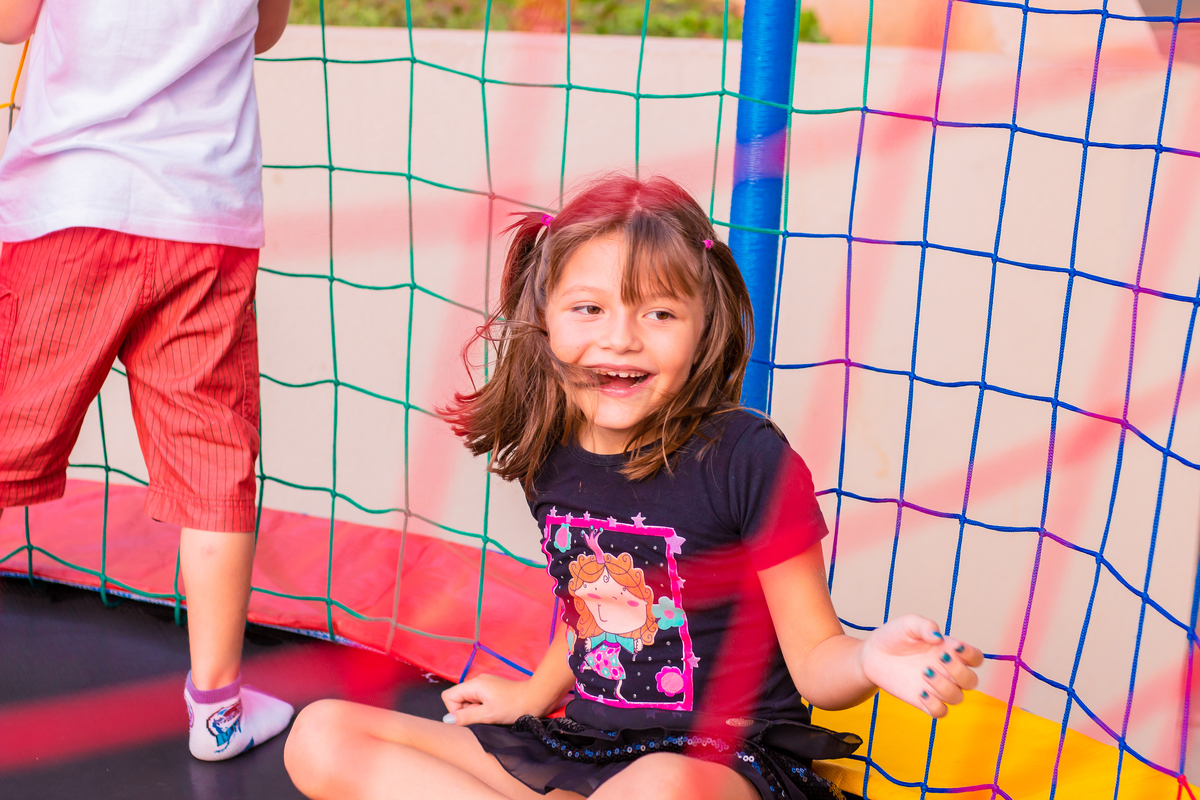 menina pulando na cama elástica