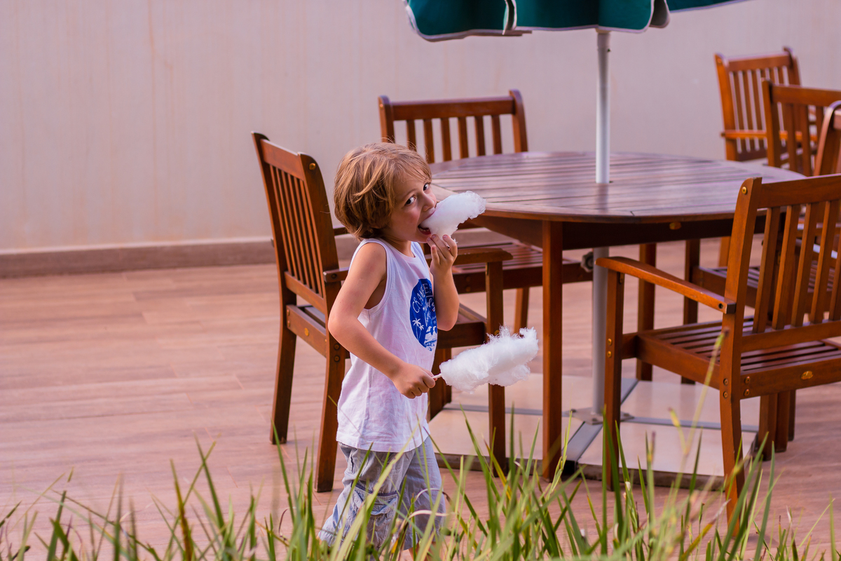 criança comendo algodão doce em aniversário