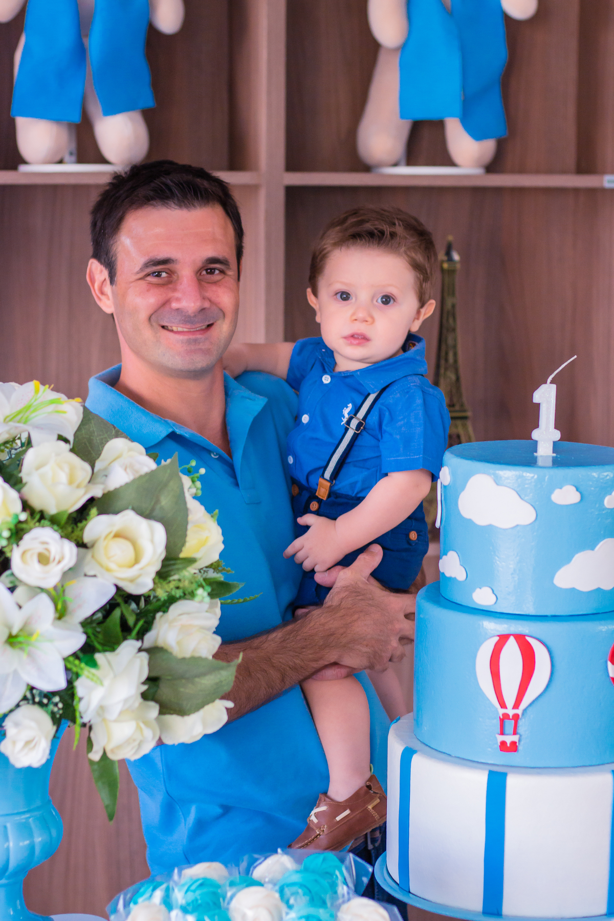 pai e aniversariante na mesa do bolo