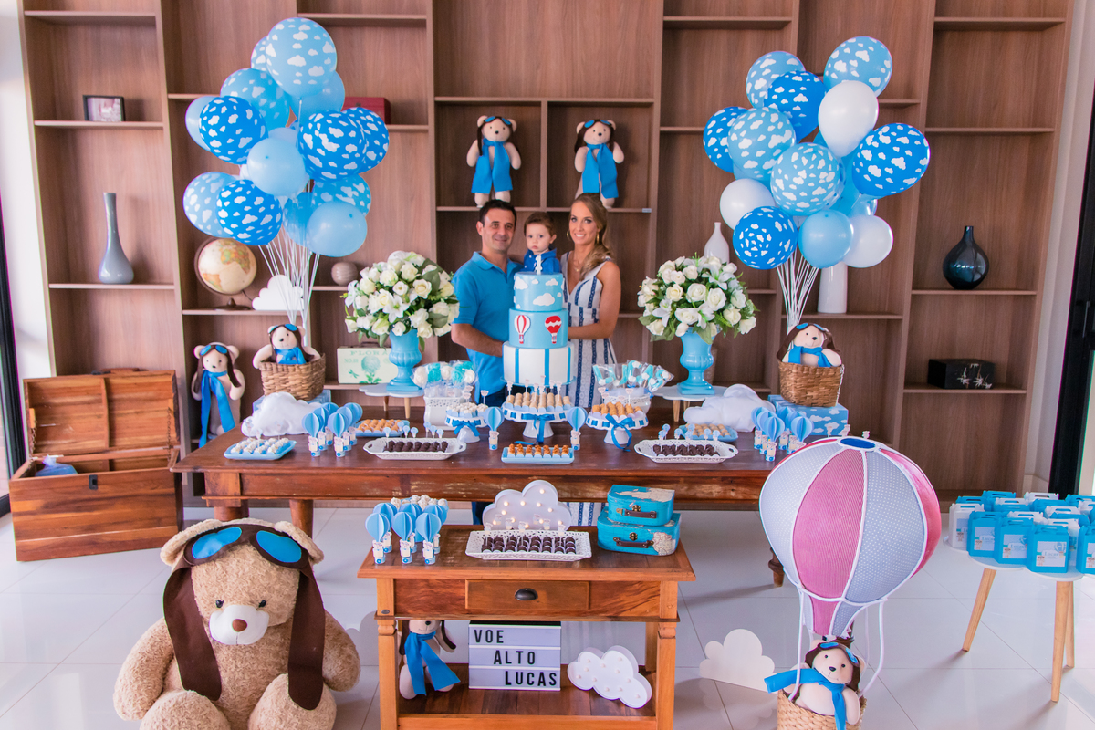 pais e aniversariante na mesa do bolo