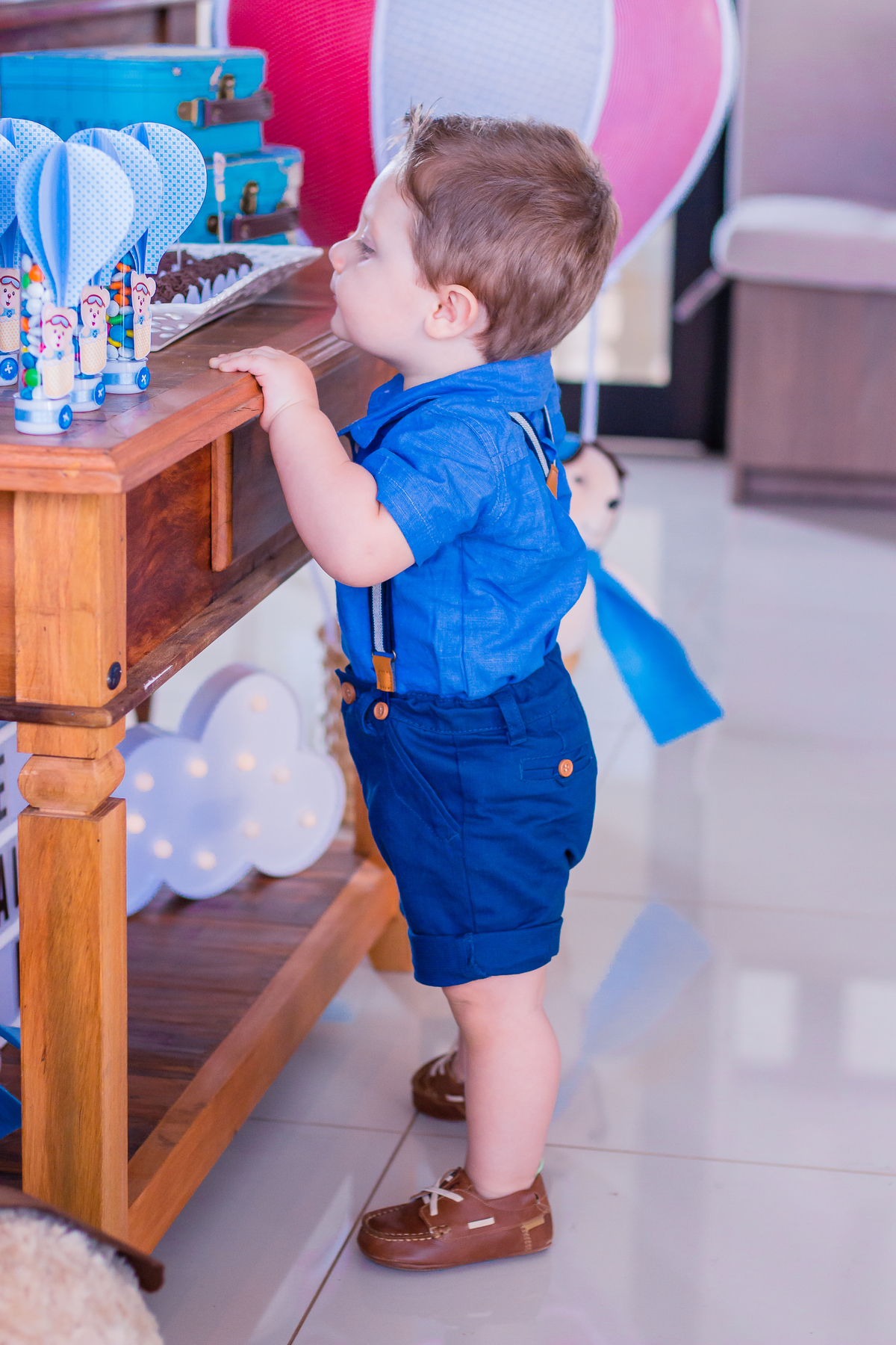 aniversariante brincando na mesa do bolo